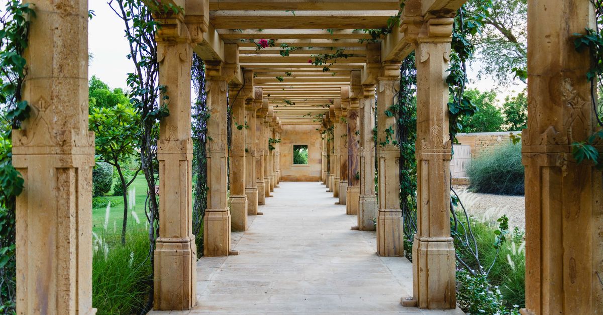 Explore a tranquil garden walkway with stone pillars, located in Jaisalmer, Rajasthan, India.