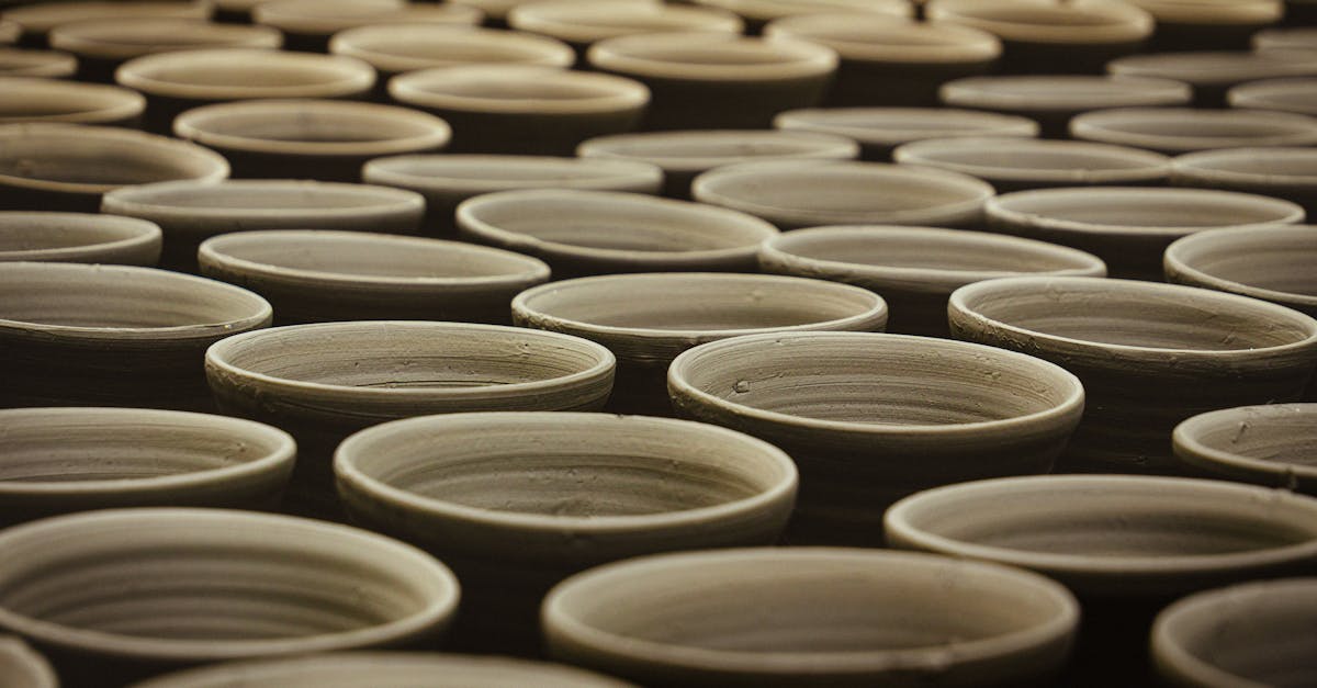 Multiple handcrafted clay pots aligned in a traditional pottery workshop.