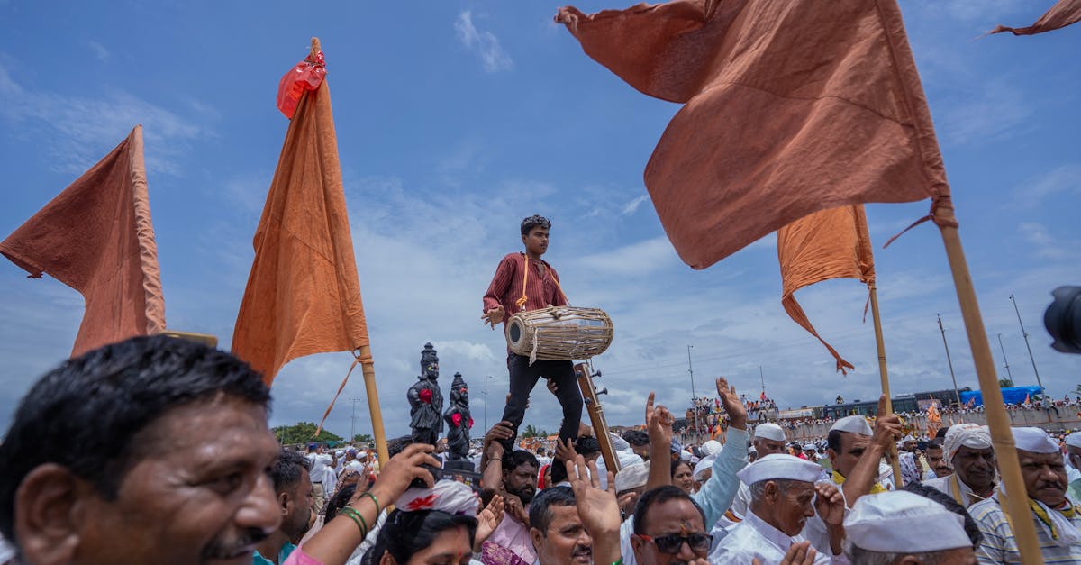 Vibrant scene of a parade in Pandharpur, featuring a traditional drummer and orange flags.