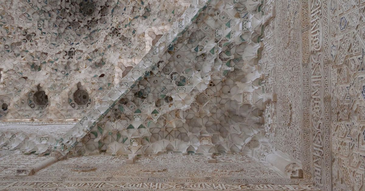 Detailed view of Moorish geometric plasterwork in the Alhambra, highlighting Islamic art and architecture.
