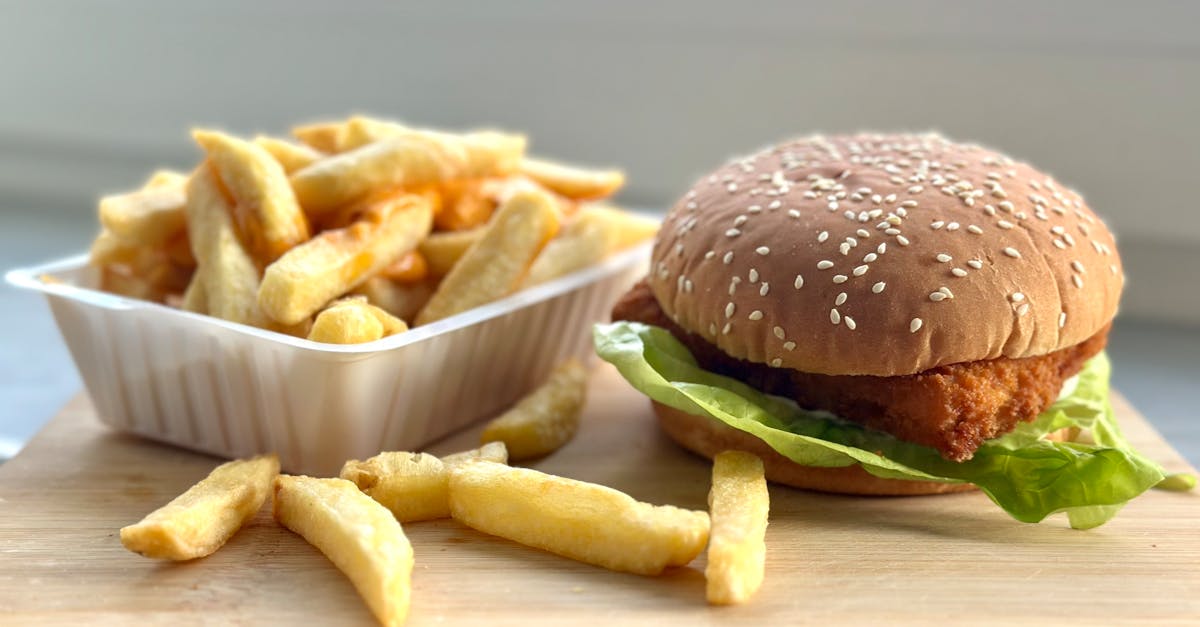 Delicious crispy chicken burger with lettuce and a side of golden fries for a perfect meal.
