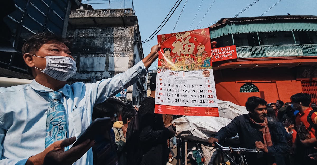 A street vendor displays a calendar in a bustling Kolkata market, showcasing diverse culture.