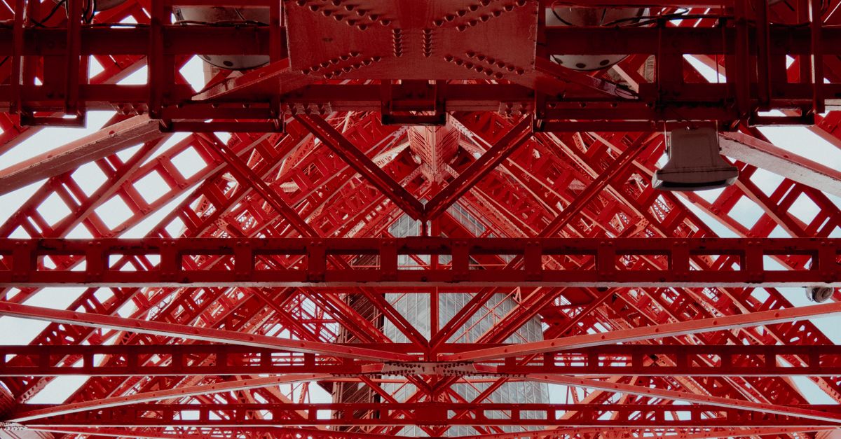 Detailed view of a red steel framework showing geometric patterns and industrial design.