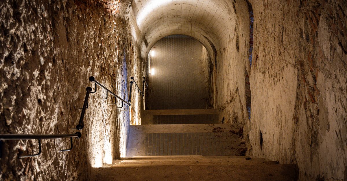 Explore a dimly lit stone staircase in Budapest's underground tunnel.