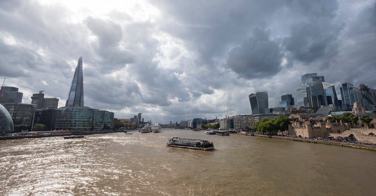 Skyline of London with the Shard and Thames River under dramatic clouds.