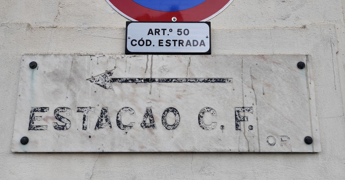 No parking sign with Portuguese C.F. station plaque on a wall in Águeda, Portugal.