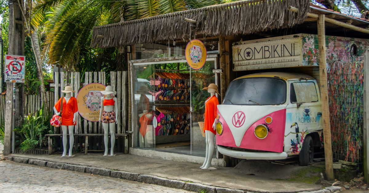 A charming swimwear store in Bahia, Brazil, featuring colorful mannequins and a vintage VW van decor.