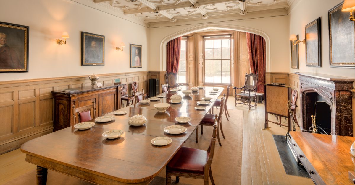 Beautifully set dining room in a historic Scottish manor, featuring vintage furniture and classic paintings.