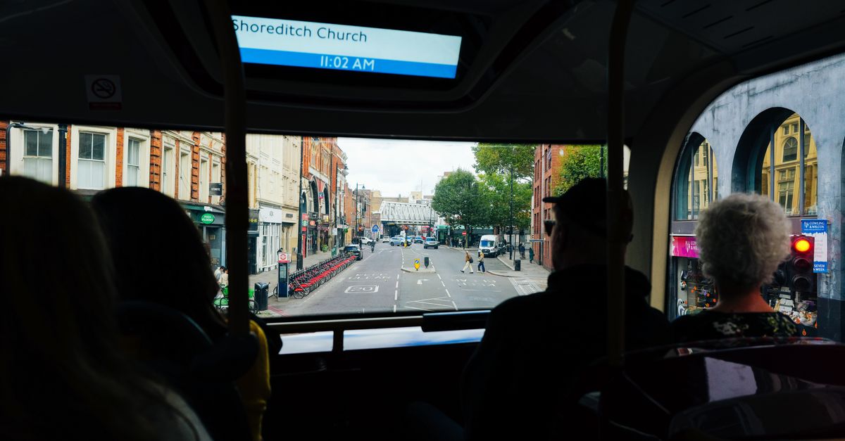 People enjoying city view from bus in Shoreditch London, showing urban scene.