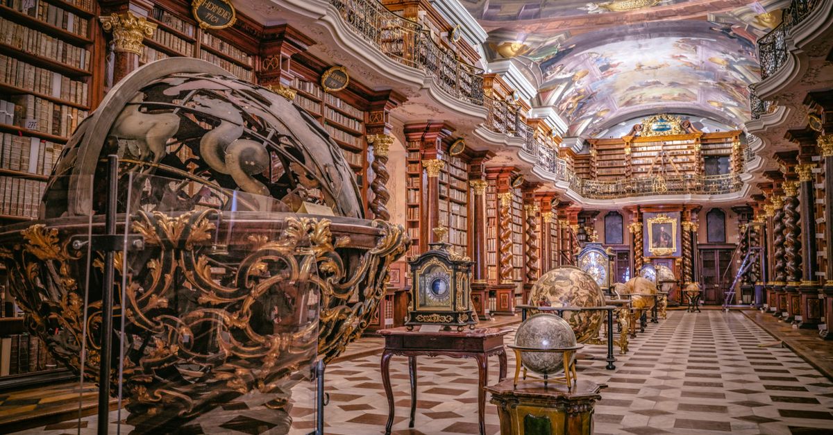 A beautifully decorated historical library with celestial globes and intricate ceiling art.