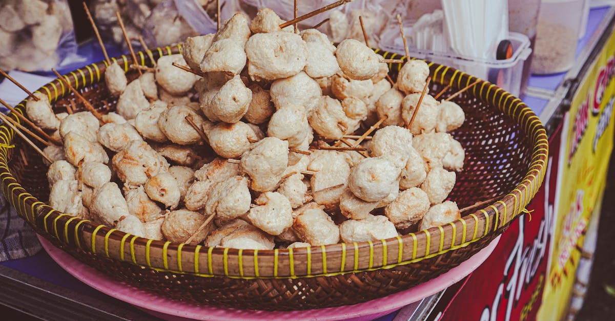 Appetizing skewered street food displayed in a traditional basket at an outdoor market.