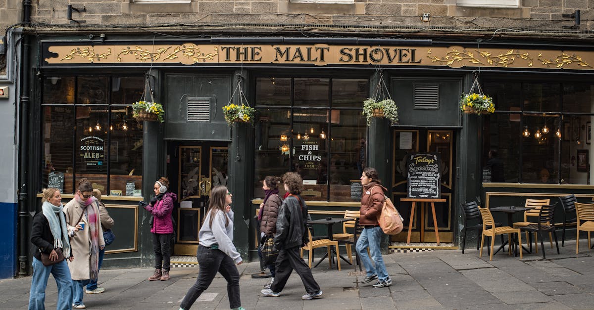 Street scene with people walking past 'The Malt Shovel' pub in Edinburgh, Scotland.