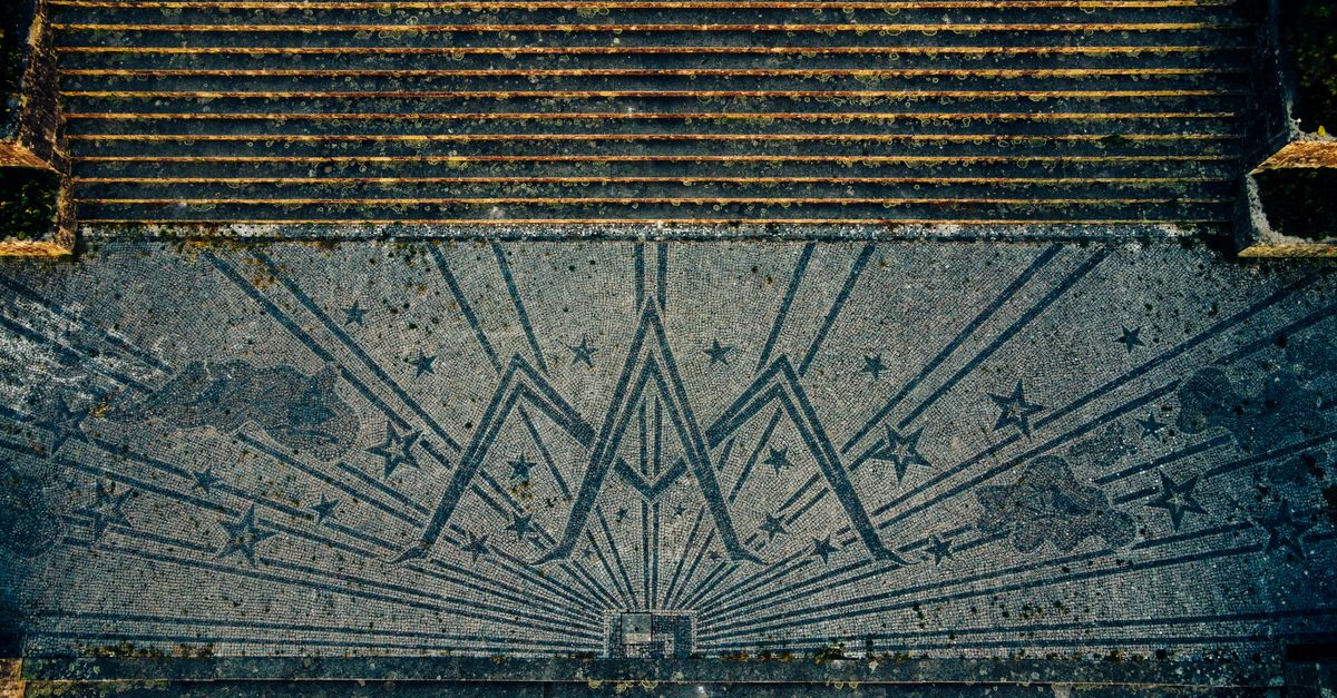 Top-down shot of a detailed mosaic with geometric patterns and stars on a staircase.