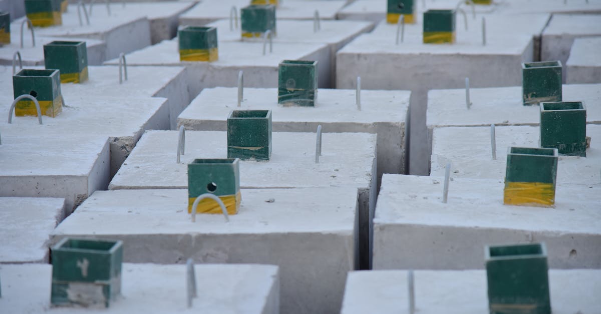 Close-up of concrete foundation blocks with embedded metal rods, ready for construction.