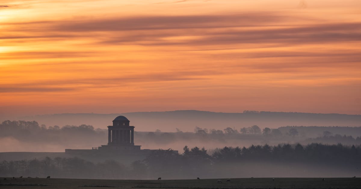 Majestic sunset sky over peaceful hilly terrain with domed mausoleum located on territory of Castle Howard in North Yorkshire