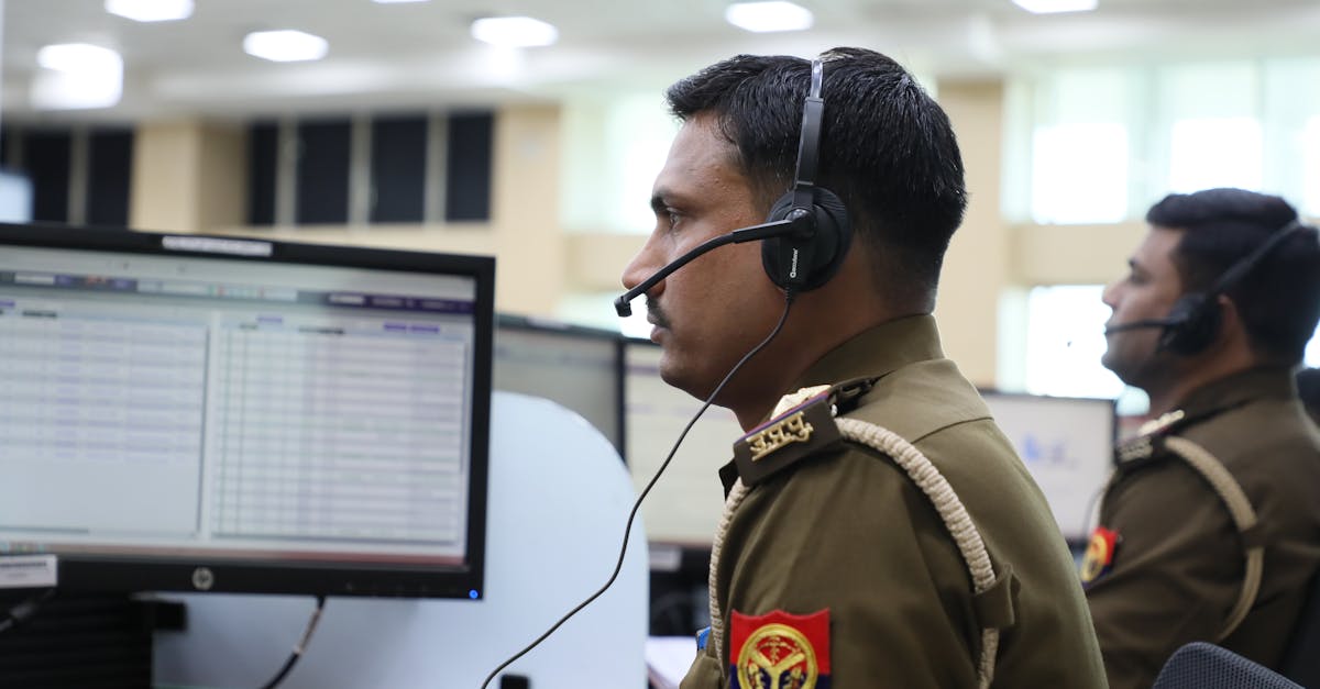 Indian police officers working at a dispatch center, focused and equipped with headsets.