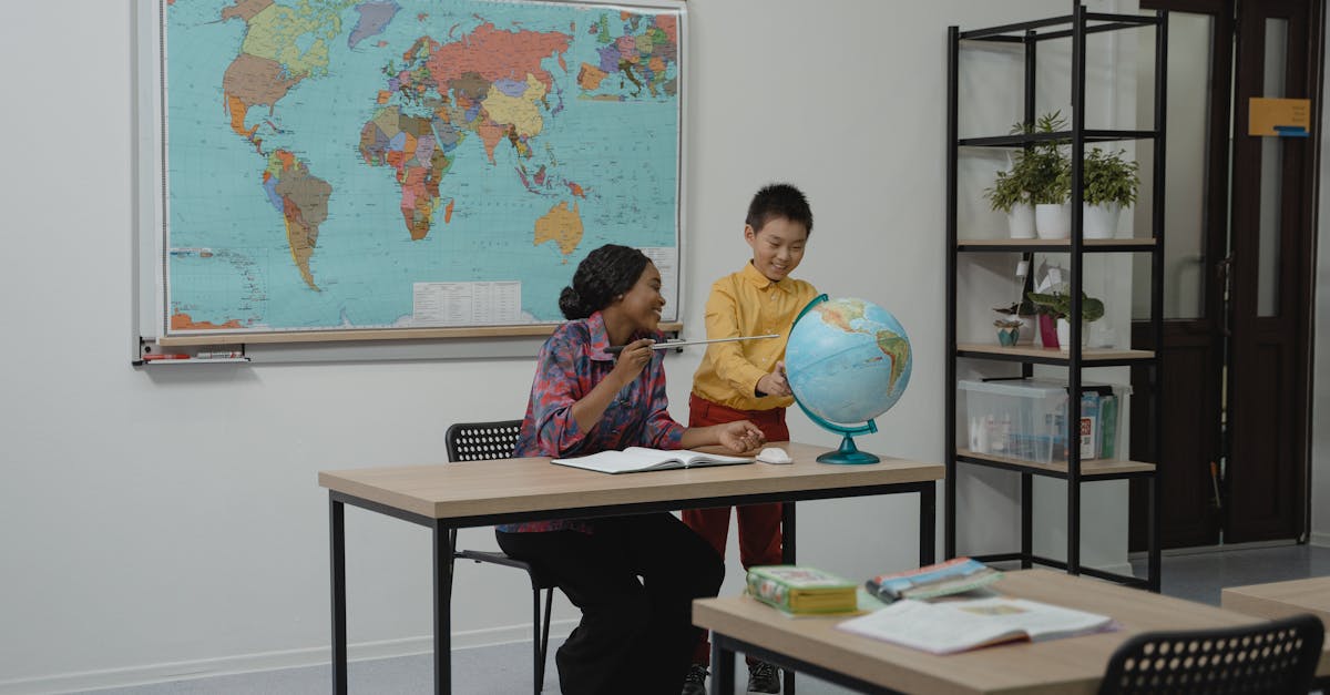 A teacher and student looking at a globe in a modern classroom setting, with a world map on the wall.