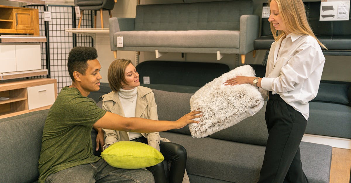 A couple explores pillow options with a saleswoman in a modern furniture store.