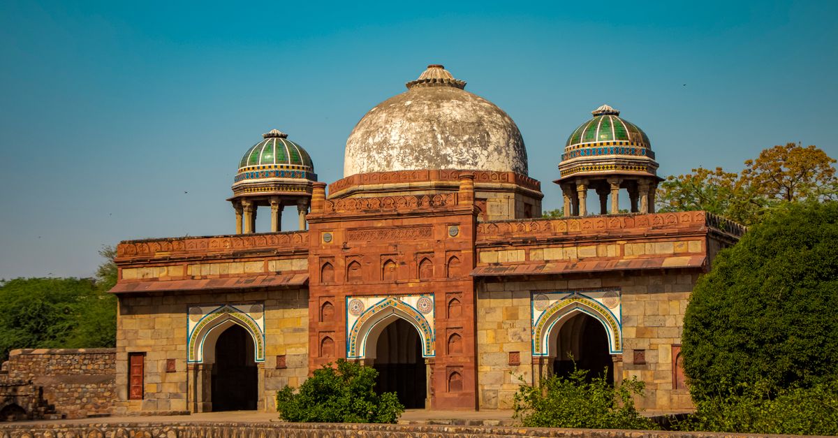 Isa Khan's Tomb with intricate architecture under a clear blue sky in Delhi, India.