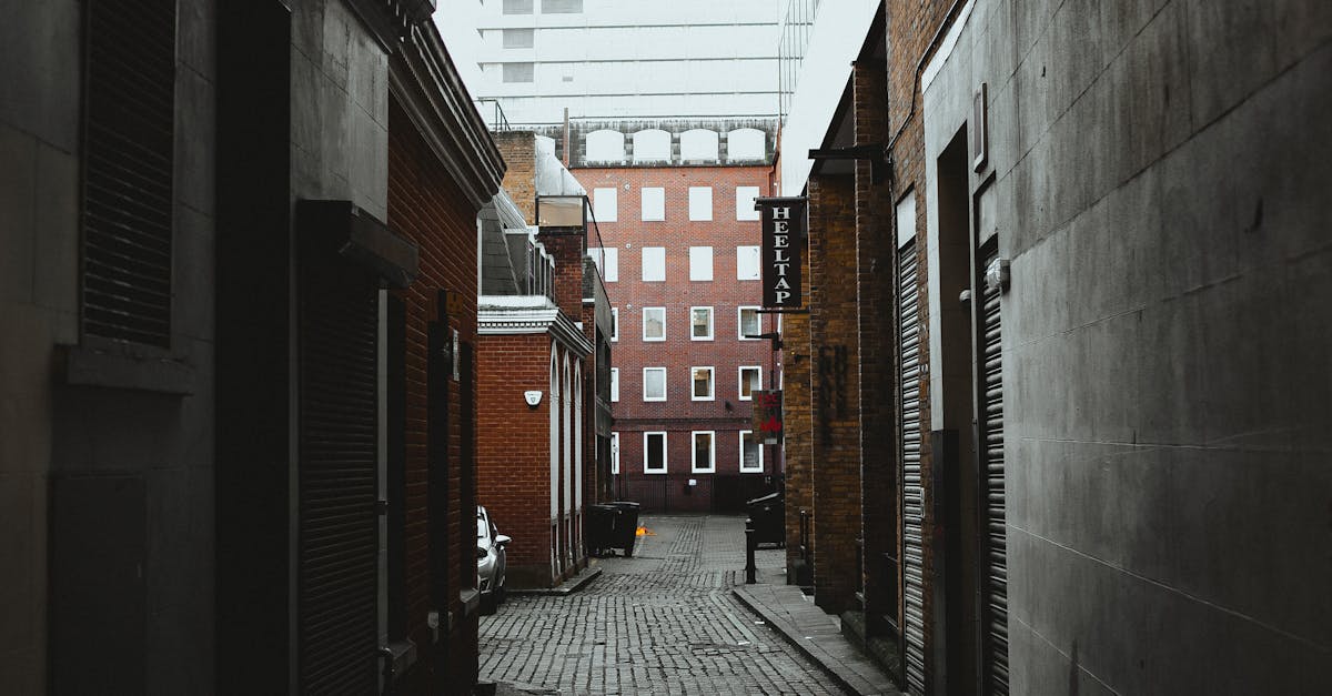 Explore a quiet, narrow alleyway framed by historic brick buildings in London, UK.
