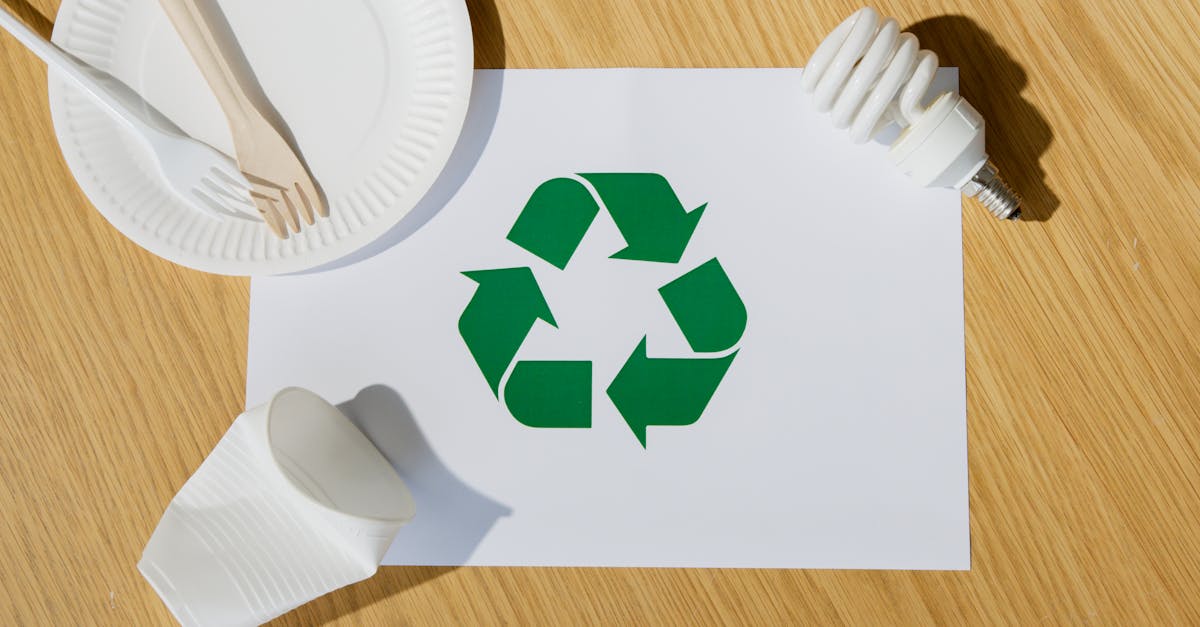Eco-friendly utensils, light bulb, and recycling symbol on paper emphasize sustainable living.