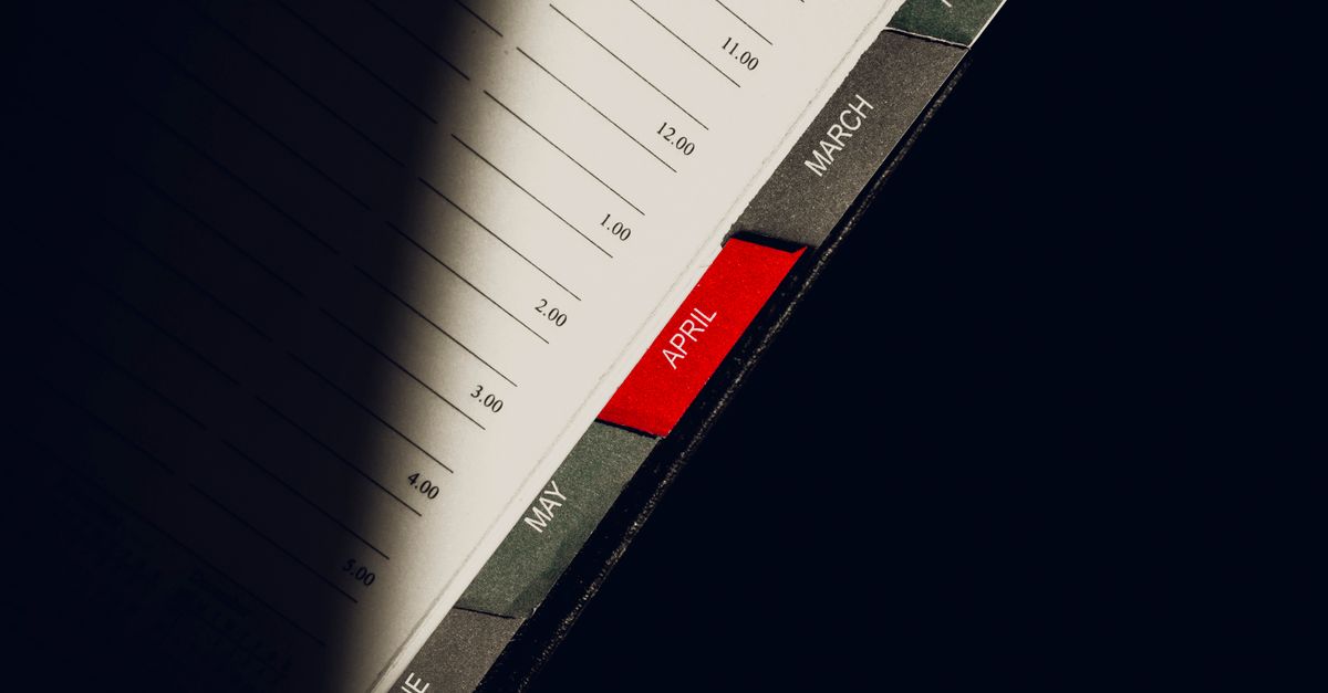 A close-up shot of a planner highlighting the month of April with visible monthly tabs.