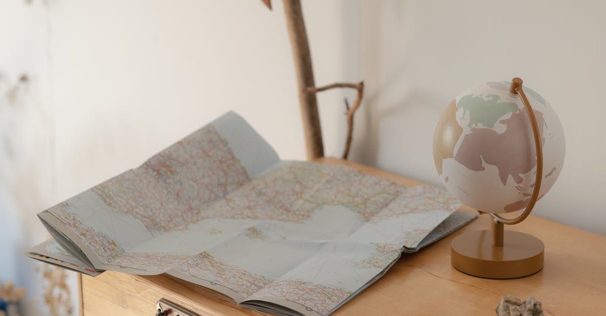 Cozy setting of a vintage map and globe on a wooden table, symbolizing travel exploration.
