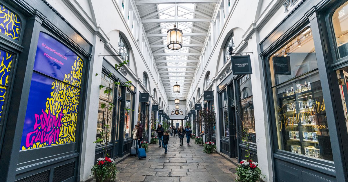 Explore the bustling Covent Garden shopping arcade in London, a blend of modern retail and classic architecture.
