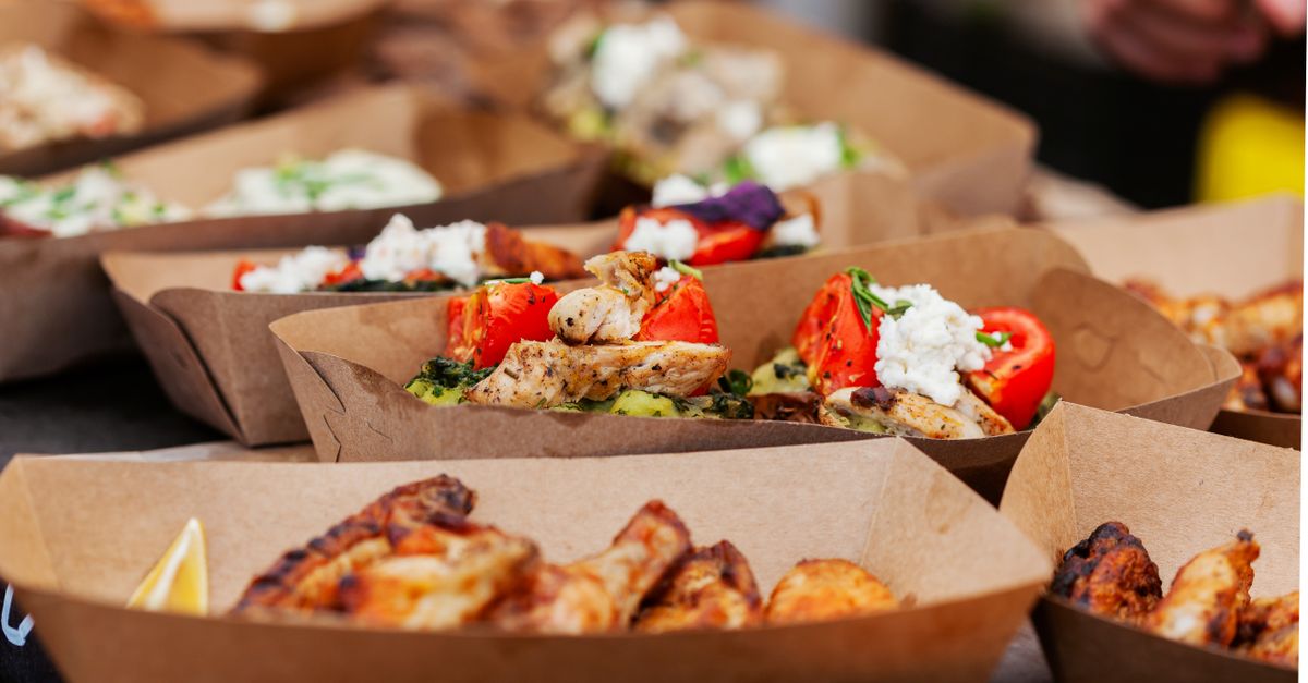 Delicious chicken dishes with vegetables served in eco-friendly paper containers.