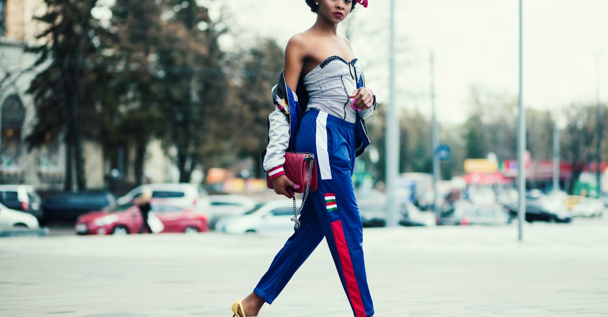 Stylish woman in vibrant outfit walking confidently in cityscape environment.