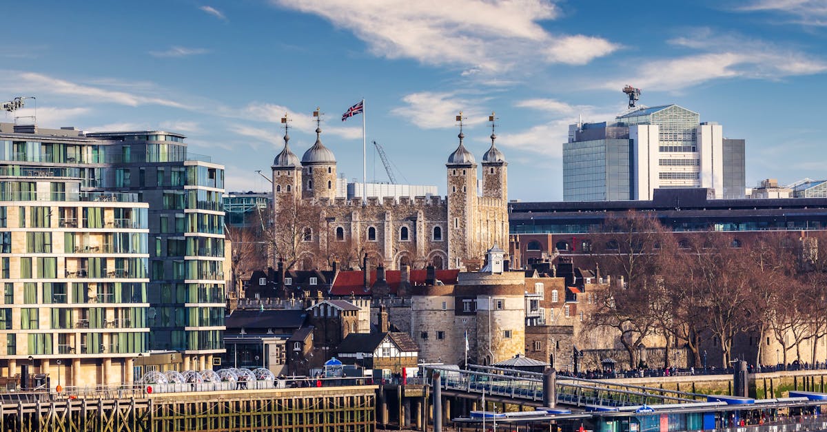 View of the historical Tower of London amidst the modern cityscape on a clear day.