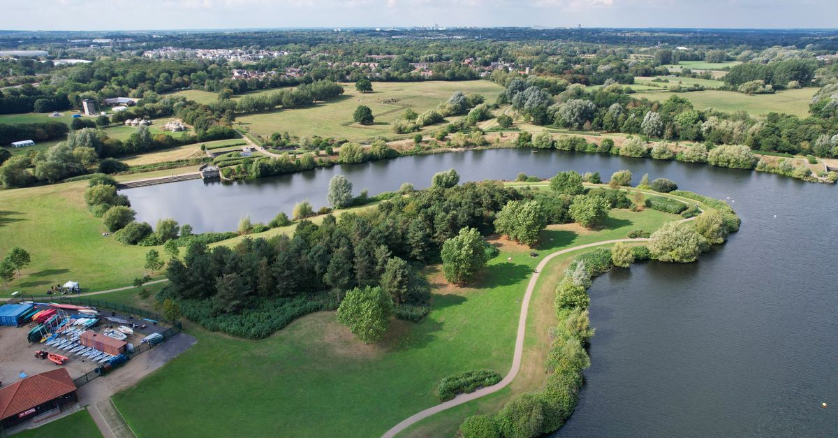 A picturesque aerial view of Willen Lake surrounded by lush greenery in Milton Keynes, England.